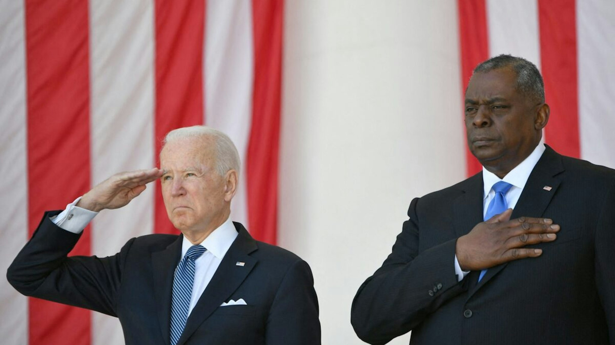 US President Joe Biden(L) salutes along with Secretary of Defense Lloyd Austin before delivering an address at the 153rd National Memorial Day Observance at Arlington National Cemetery on Memorial Day in Arlington, Virginia on May 31, 2021.