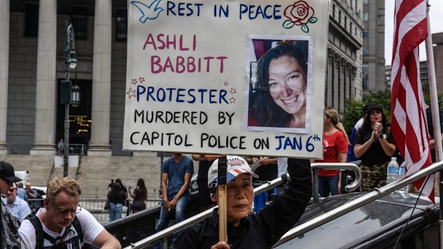 A right wing protester holds a sign about Ashli Babbitt while participating in a political rally on July 25, 2021 in New York City.
