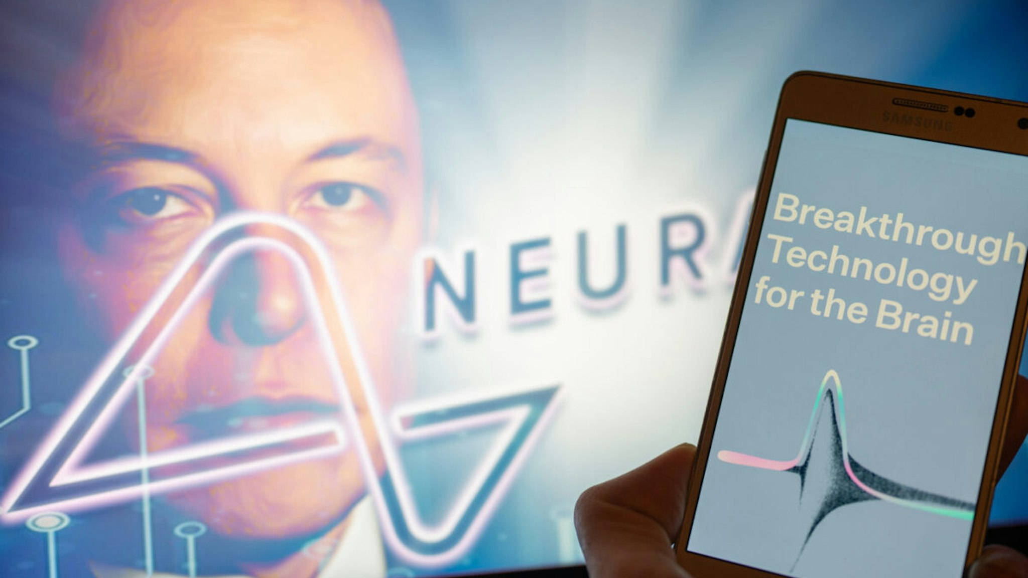 Neuralink logo displayed on mobil with founder Elon Musk seen on screen in the background. Neuralink Corporation is a neurotechnology company that develops implantable brain-computer interfaces. In Brussels on 4 December 2022.