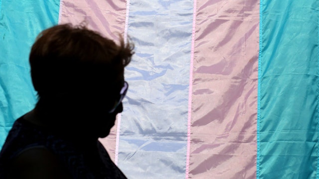 A person walks past a Transgender flag during The TransFest 2023 in the Queens borough of New York City on July 29, 2023. (Photo by Leonardo Munoz / AFP) (Photo by LEONARDO MUNOZ/AFP via Getty Images)