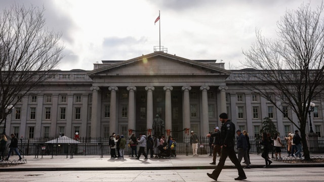 Pedestrians walk past the US Department of the Treasury in Washington, DC, US, on Thursday, Dec. 28, 2023. The market's reaction to the Federal Reserve's pivot toward interest-rate cuts this month has boosted expectations that would-be public companies may accelerate their IPO timelines.