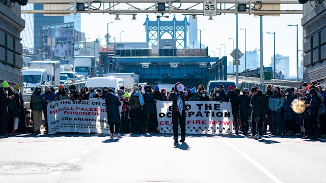 Pro-Palestinian protesters are pictured blocking traffic on the Manhattan Bridge in Manhattan on Monday, Jan. 8, 2024.