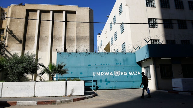 A Palestinian man walks past the building of the UNRWA headquarters in Gaza City on January 8, 2018. - Israeli Prime Minister Benjamin Netanyahu called for the closure of the United Nations agency for Palestinian refugees, days after US President Donald Trump threatened to cut Palestinian aid.
