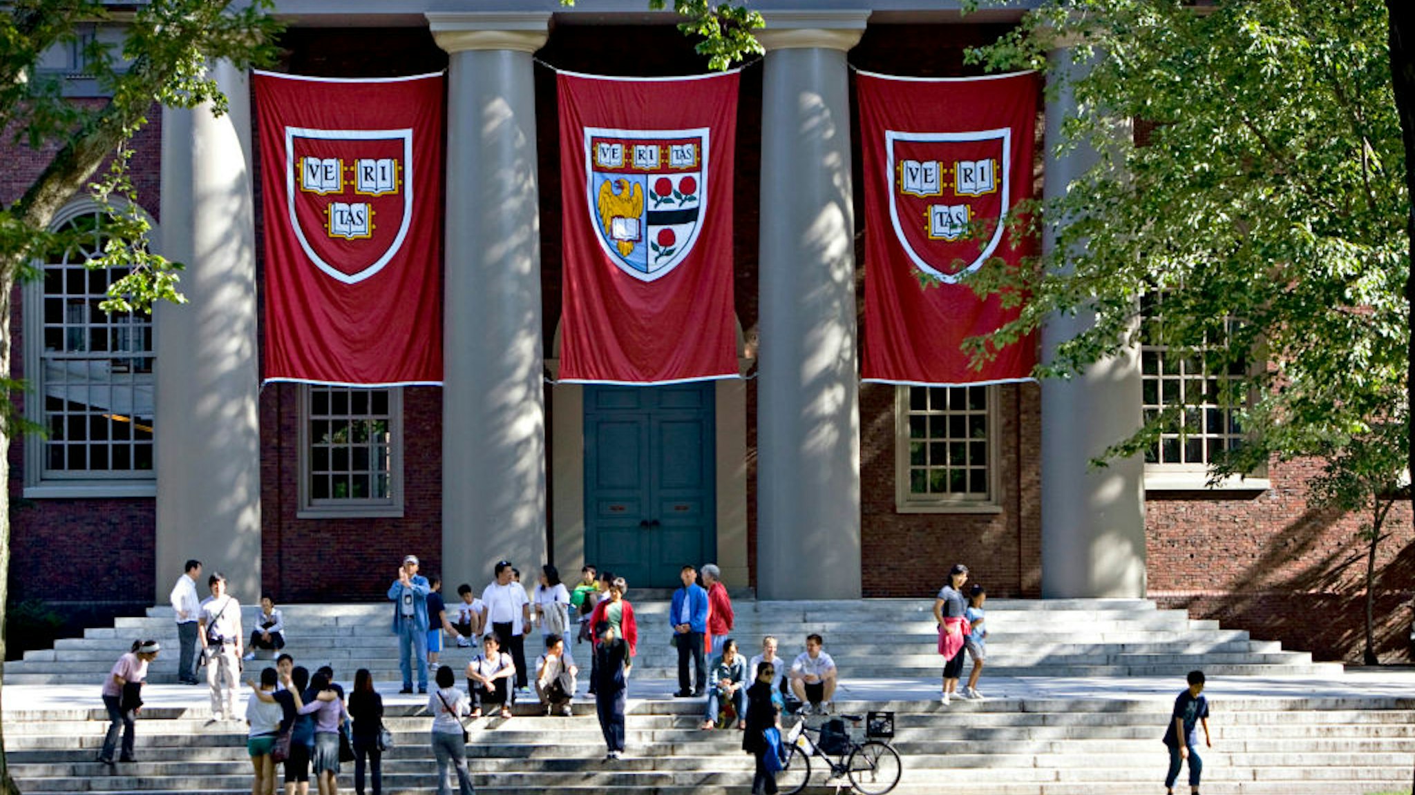 UNITED STATES - SEPTEMBER 03: Harvard banners hang outside Memorial Church on the Harvard University campus in Cambridge, Massachusetts, U.S., on Friday, Sept. 4, 2009. Community activists in Allston, a section of Boston across the Charles River from Harvard's main campus in Cambridge, say university delays have left a (Photo by Michael Fein/Bloomberg via Getty Images)