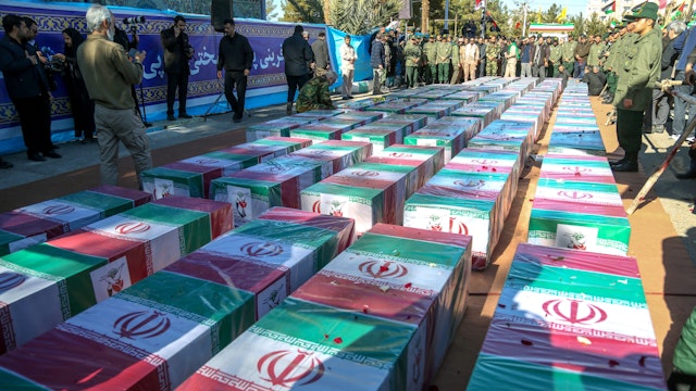 KERMAN, IRAN - JANUARY 5: Iranian mourners gather around coffins wrapped with the Iranian flags during the funeral ceremony for victims of yesterday's explosion on January 5, 2024, in Kerman, Iran. On Wednesday, 84 people were killed here when bombs exploded during a memorial procession to mark the fourth anniversary of Qasem Soleimani's assassination by the US. Soleimani was the head of the Revolutionary Guards' overseas operations arm, the Quds Force. No group has yet claimed responsibility for Wednesday's bombing.