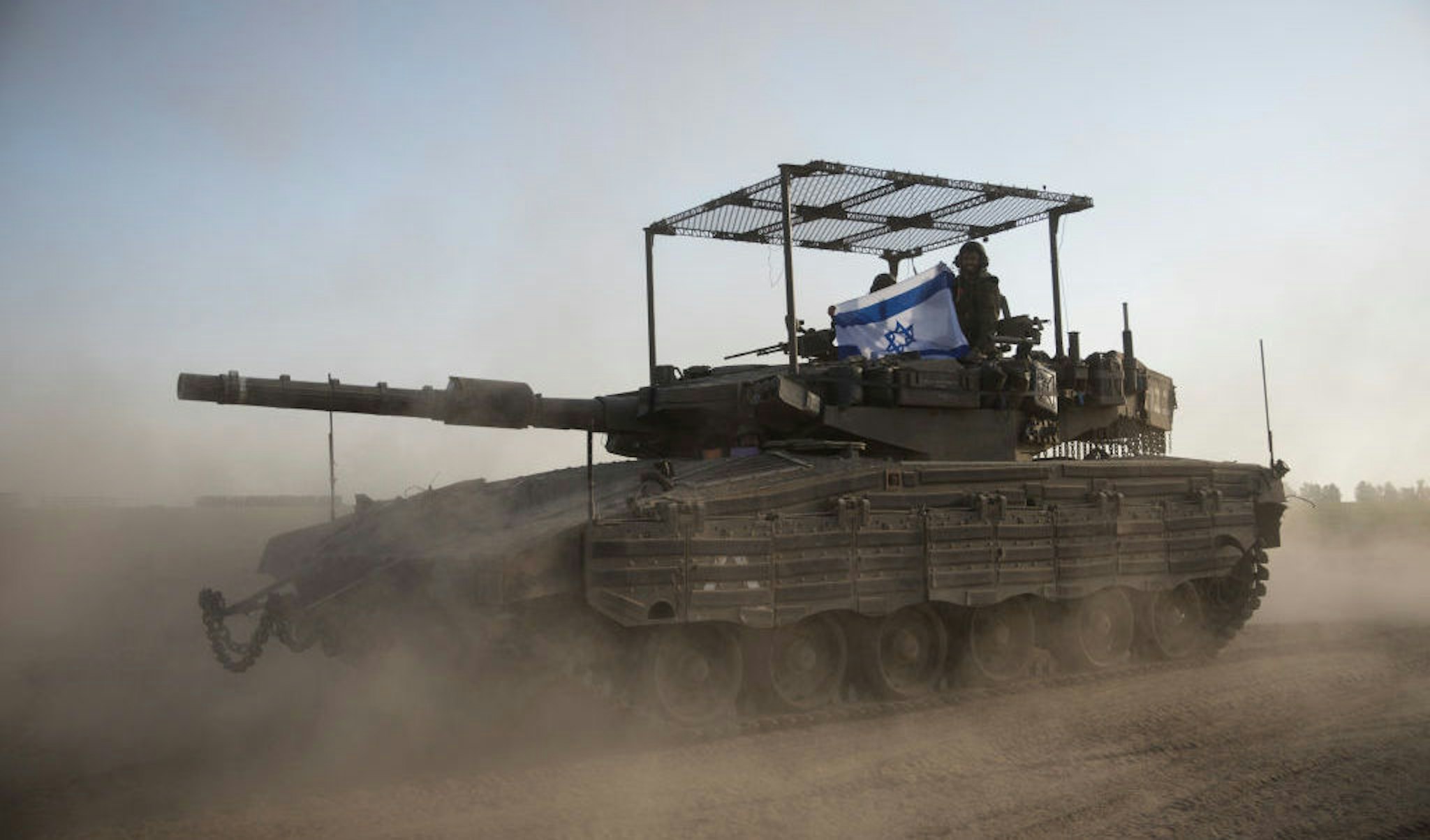 Israeli soldiers hold an Israeli flag on a tank that is moving along the border with Gaza Strip on January 21, 2024 in Southern Israel, Israel. (Photo by Amir Levy/Getty Images)