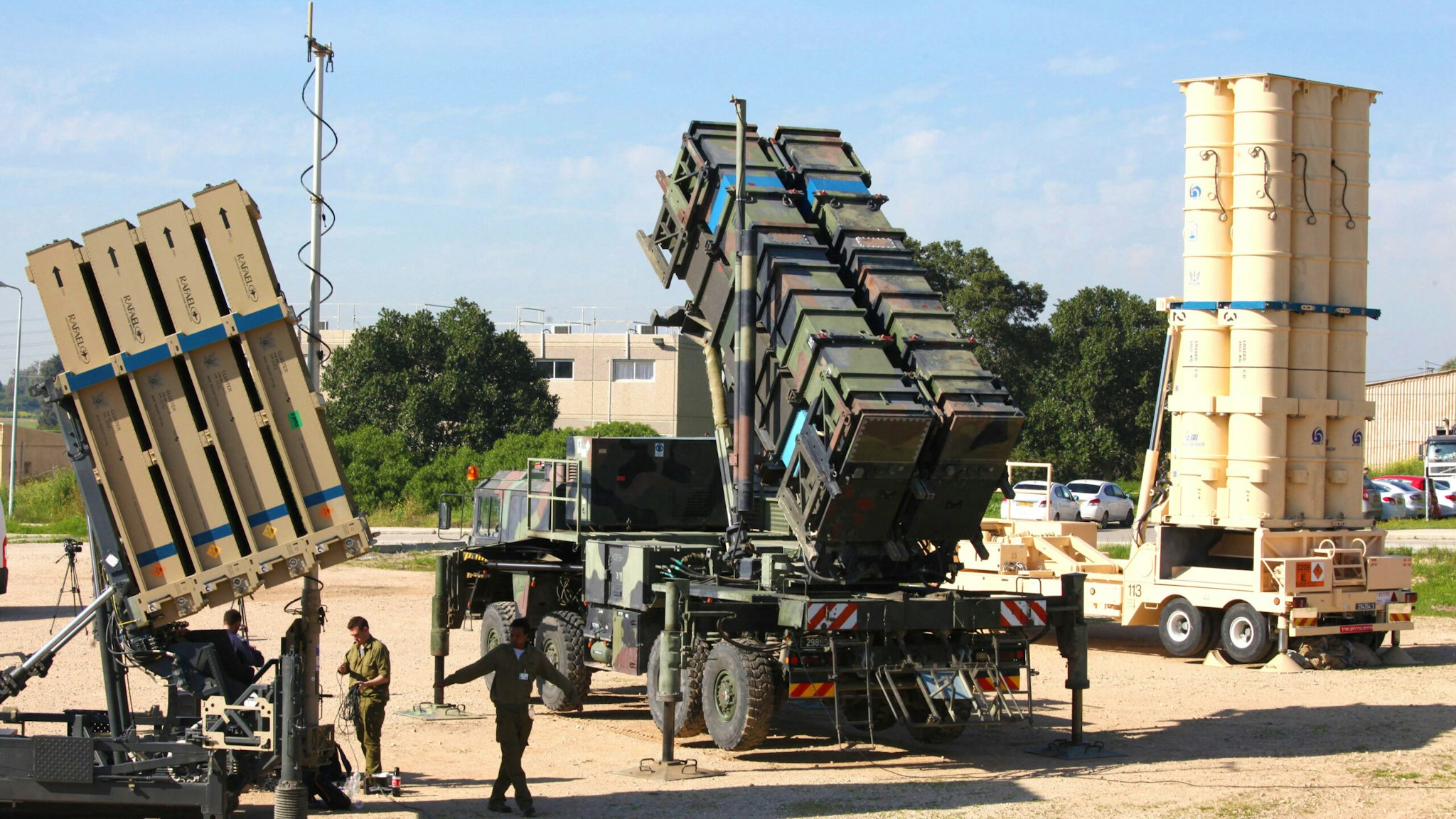 Israeli soldiers walk near an Israeli Irone Dome defence system (L), a surface-to-air missile (SAM) system, the MIM-104 Patriot (C), and an anti-ballistic missile the Arrow 3 (R) during Juniper Cobra's joint exercise press briefing at Hatzor Israeli Air Force Base in central Israel, on February 25, 2016. - Juniper Cobra, is held every two years where Israel and the United States train their militaries together to prepare against possible ballistic missile attacks, as well as allowing the armies to learn to better work together.