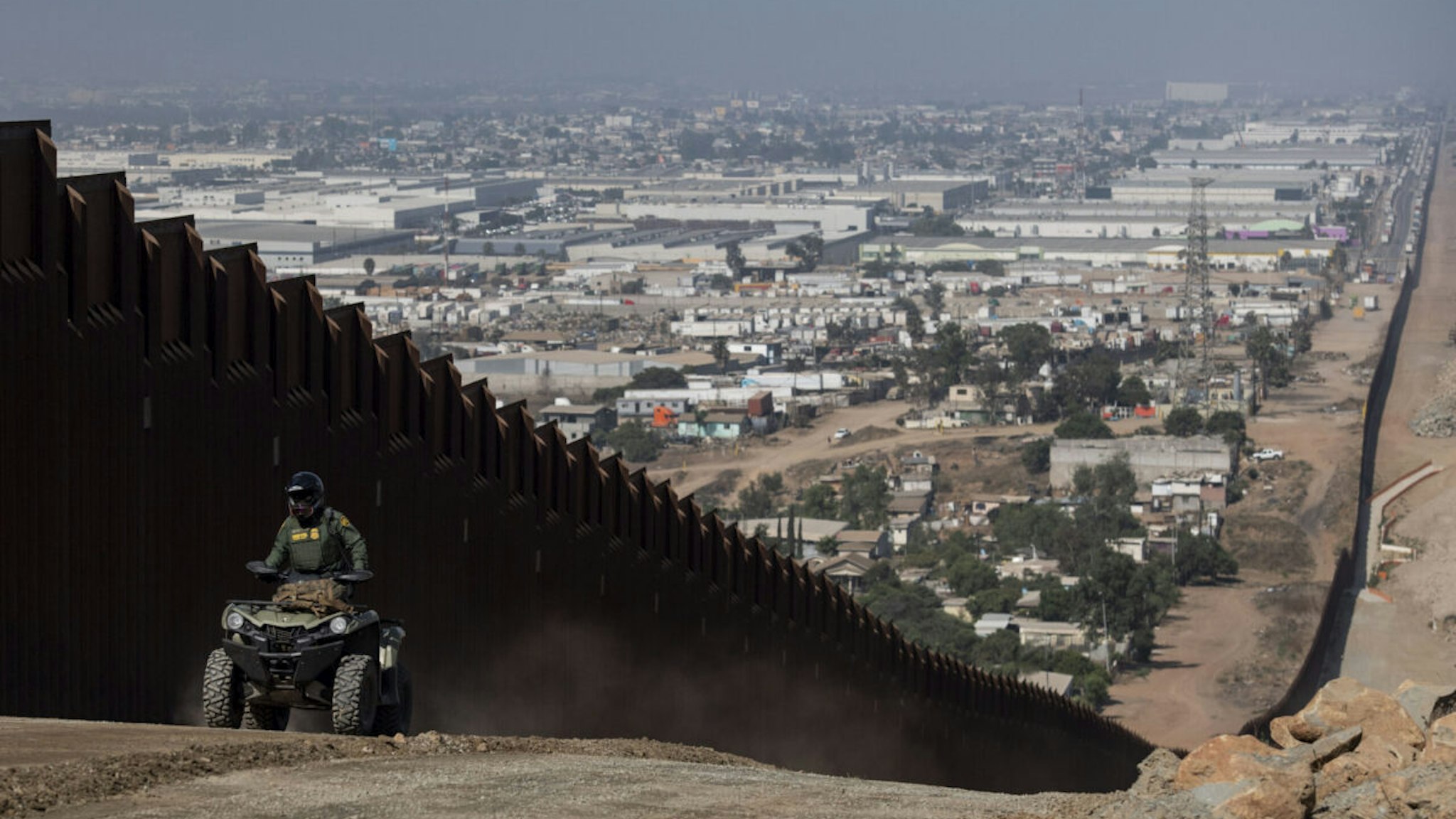 SAN DIEGO, CA - AUGUST 22: A border patrol agent patrols along a construction site for the secondary border fence which follows the length of the primary border fence that separates the United States and Mexico in the San Diego Sector on August 22, 2019 in San Diego, CA.