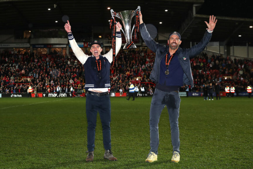 WREXHAM, WALES - APRIL 22: Rob McElhenney and Ryan Reynolds, Owners of Wrexham celebrate with the Vanarama National League trophy as Wrexham win the Vanarama National League and are promoted to the English Football League after victory in the Vanarama National League match between Wrexham and Boreham Wood at Racecourse Ground on April 22, 2023 in Wrexham, Wales. (Photo by Jan Kruger/Getty Images)