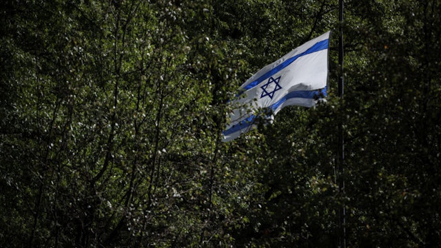 The Israeli flag is seen through the trees at the Israeli embassy on October 8, 2023 in Washington, DC