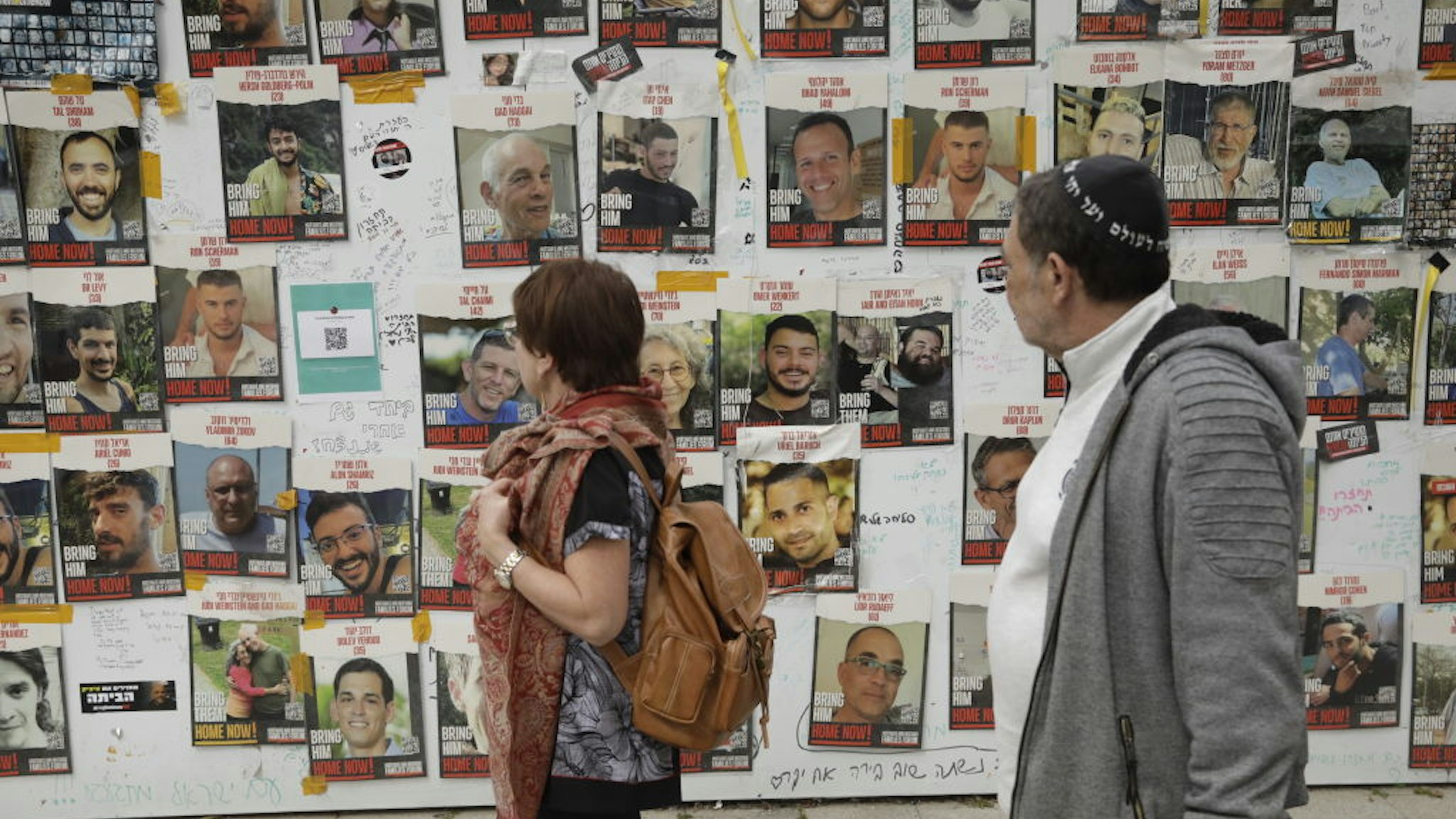 TEL AVIV, ISRAEL - FEBRUARY 12: People view posters of missing Israelis on a wall at Hostages Square on February 12, 2024 in Tel Aviv, Israel. The Israeli military says it has rescued two hostages from captivity in Rafah, whilst two 21-year old IDF soldiers were killed in overnight fighting in the Gaza Strip. The IDF has now rescued three hostages through military operations since Oct. 7, as PM Netanyahu faces pressure from relatives of freed hostages to secure the release of the remaining captives through negations with Hamas. (Photo by Amir Levy/Getty Images)