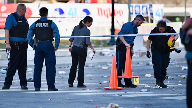 Police officers investigate the scene of a shooting where at least one person was killed and more than 20 others were injured after the Kansas City Chiefs' Super Bowl LVIII victory parade on Feb. 14, 2024, in Kansas City, Missouri.