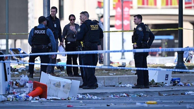 Police officers investigate the scene of a shooting where at least one person was killed and more than 20 others were injured after the Kansas City Chiefs Super Bowl LVIII victory parade Wednesday, Feb. 14, 2024, in Kansas City.