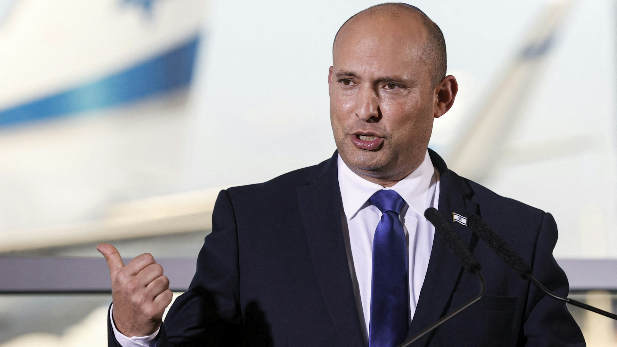 Israeli Prime Minister Naftali Bennett addresses reporters at Ben Gurion International Airport on June 22, 2021. - Israeli Prime Minister Naftali Bennett said that a rise in cases was "a new outbreak" and urged Israelis to cancel their flights abroad and vaccinate their children to head off runaway infections.