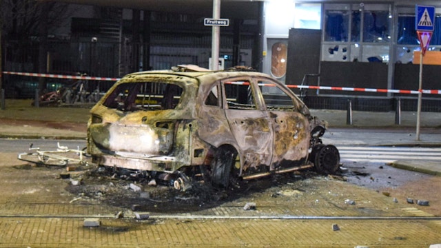 HAGUE, NETHERLANDS - FEBRUARY 17: A burned vehicle is seen at the Opera hall center on the Fruitweg following clashes between two groups of Eritreans during riots after a meeting in the conference center in The Hague on February 17, 2024.