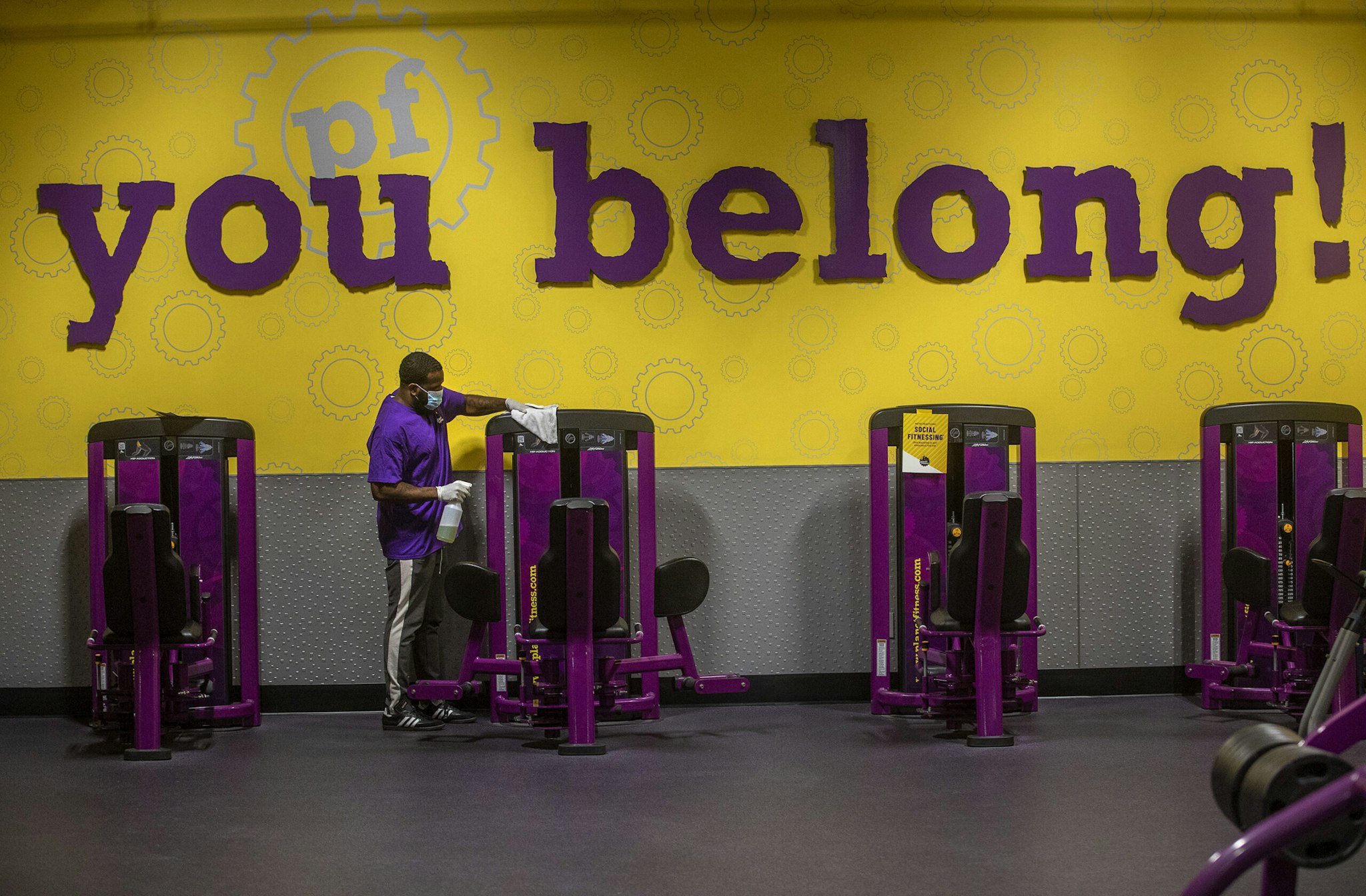 INGLEWOOD, CA - MARCH 15: Anthony Carthan, an employee at Planet Fitness on Imperial Highway in Inglewood, disinfects exercise equipment while helping to prepare the fitness center for their re-opening tomorrow morning at 5am after being closed since July of 2020. Exercise equipment is spaced apart to ensure social distancing and the new guidelines allow for a maximum of 10 percent of capacity.