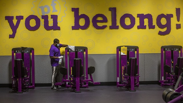 INGLEWOOD, CA - MARCH 15: Anthony Carthan, an employee at Planet Fitness on Imperial Highway in Inglewood, disinfects exercise equipment while helping to prepare the fitness center for their re-opening tomorrow morning at 5am after being closed since July of 2020. Exercise equipment is spaced apart to ensure social distancing and the new guidelines allow for a maximum of 10 percent of capacity.