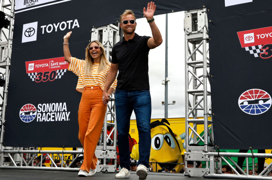 SONOMA, CALIFORNIA - JUNE 12: Actress Candace Cameron Bure and husband, and former NHL player Valeri Bure wave to NASCAR fans onstage during driver intros prior to during pre-race ceremonies prior to the NASCAR Cup Series Toyota/Save Mart 350 at Sonoma Raceway on June 12, 2022 in Sonoma, California. (Photo by Chris Graythen/Getty Images)