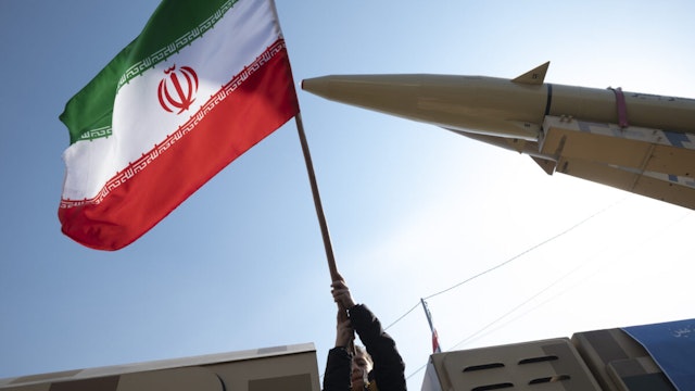 A young boy is waving an Iranian flag next to the Iranian-made Zolfaghar missile on display at Azadi (Freedom) Square in western Tehran, Iran, on February 11, 2024, during a rally to mark the 45th anniversary of the victory of Iran's 1979 Islamic Revolution. The Iranian Islamic Revolution, which led to the overthrow of the Pahlavi dynasty in 1979, replaced the Imperial State of Iran with the present-day Islamic Republic of Iran.