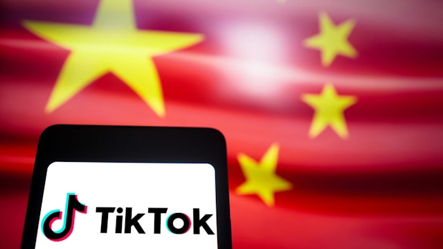 BRAZIL - 2024/03/14: In this photo illustration, the TikTok logo is displayed on a smartphone screen with the flag of China in the background.