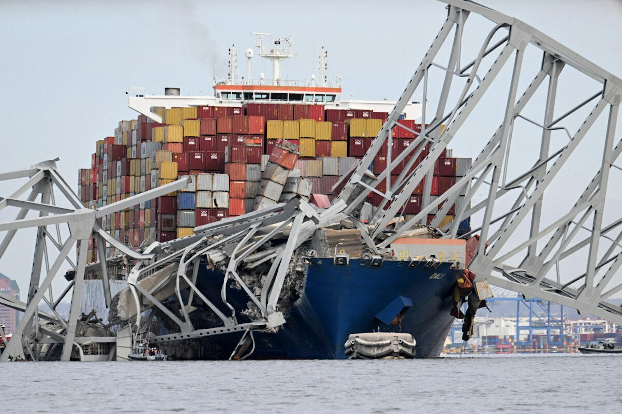 TOPSHOT - The steel frame of the Francis Scott Key Bridge sits on top of the container ship Dali after the bridge collapsed, Baltimore, Maryland, on March 26, 2024. The bridge collapsed early March 26 after being struck by the Singapore-flagged Dali, sending multiple vehicles and people plunging into the frigid harbor below. There was no immediate confirmation of the cause of the disaster, but Baltimore's Police Commissioner Richard Worley said there was "no indication" of terrorism.