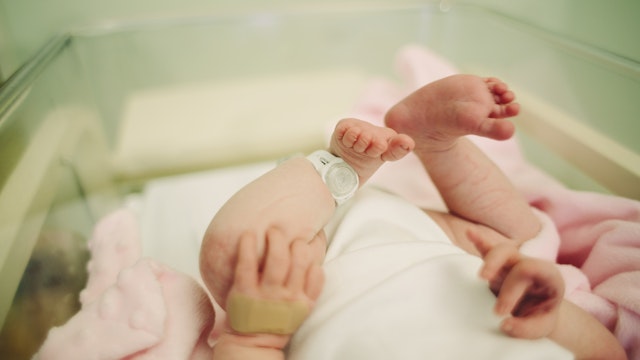 View of baby's feet with a hospital security tag on