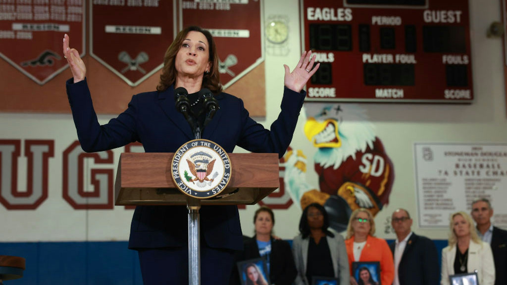 U.S. Vice President Kamala Harris speaks to the media as family members hold portraits of their loved ones who were killed during the 2018 shooting at Marjory Stoneman Douglas High School on March 23, 2024, in Parkland, Florida. (Photo by Joe Raedle/Getty Images)