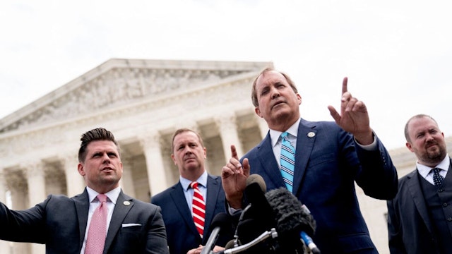 Texas Attorney General Ken Paxton (2R) speaks to reporters in front of the US Supreme Court in Washington, DC, on April 26, 2022.