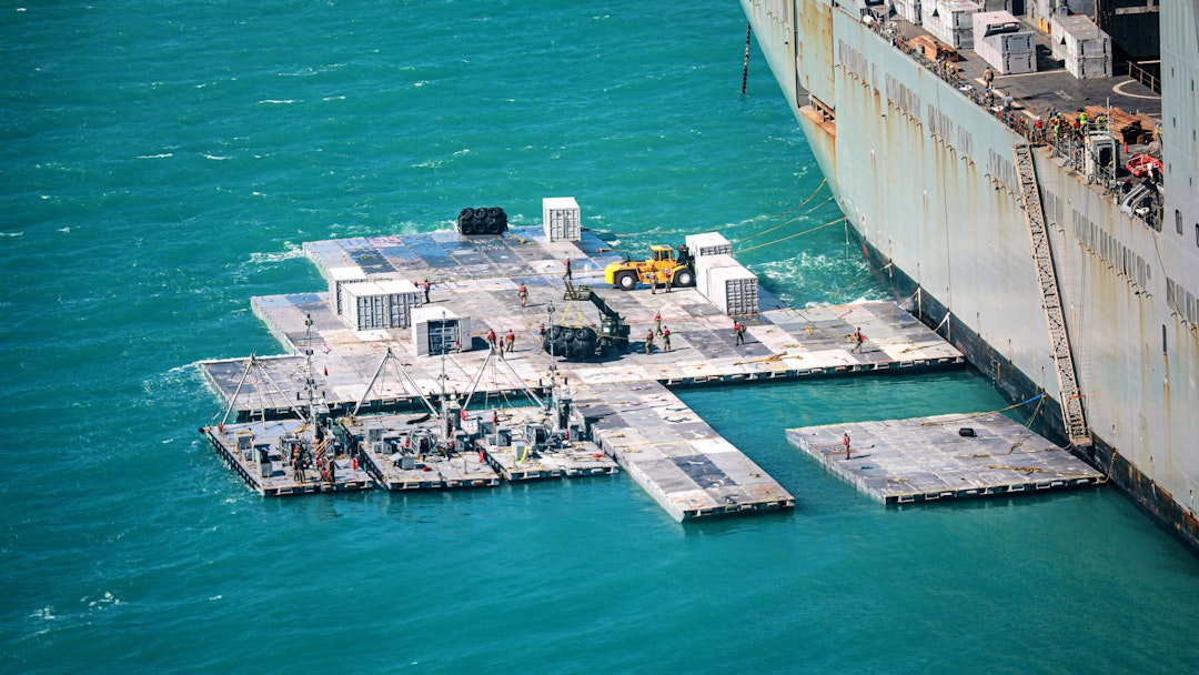 BOWEN, AUSTRALIA - JULY 29, 2023: In this handout released by the U.S. Army, Army mariners assigned to the 368th Seaport Operations Company and 331st Transportation Company construct a causeway adjacent to the MV Maj. Bernard F. Fisher off the coast of Bowen, Australia, July 29, 2023. When complete, the causeway will form a floating pier enabling the discharge of vehicles from the Fisher to shore demonstrating the critical capability of Joint Logistics Over-the-Shore during Talisman Sabre. The U.S. military has built floating causeways like this one off the Gaza Strip that would allow humanitarian aid to be delivered to Palestinians that are under bombardment from Israel.