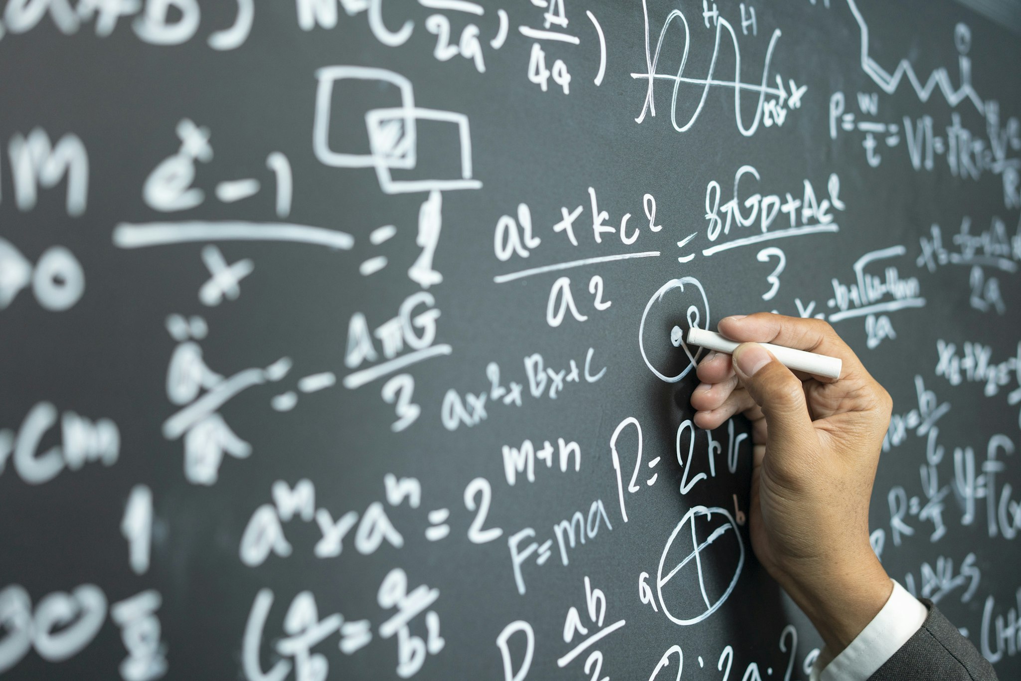 Witthaya Prasongsin. Getty Images. professor writing on the board while having a chalk and blackboard lecture (shallow DOF; color toned image)