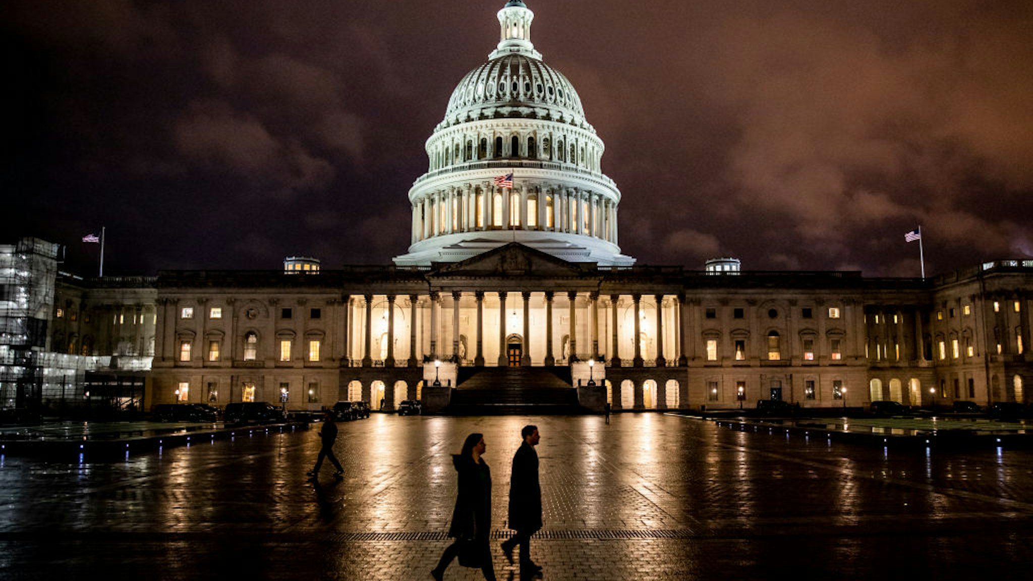 WASHINGTON, DC - DECEMBER 17: People walk along the east front plaza of the US Capitol as night falls on December 17, 2019 in Washington, DC. The House Rules Committee is holding a full committee hearing to set guidelines for the upcoming debate and vote on the two Articles of Impeachment of President Trump in the House of Representatives.