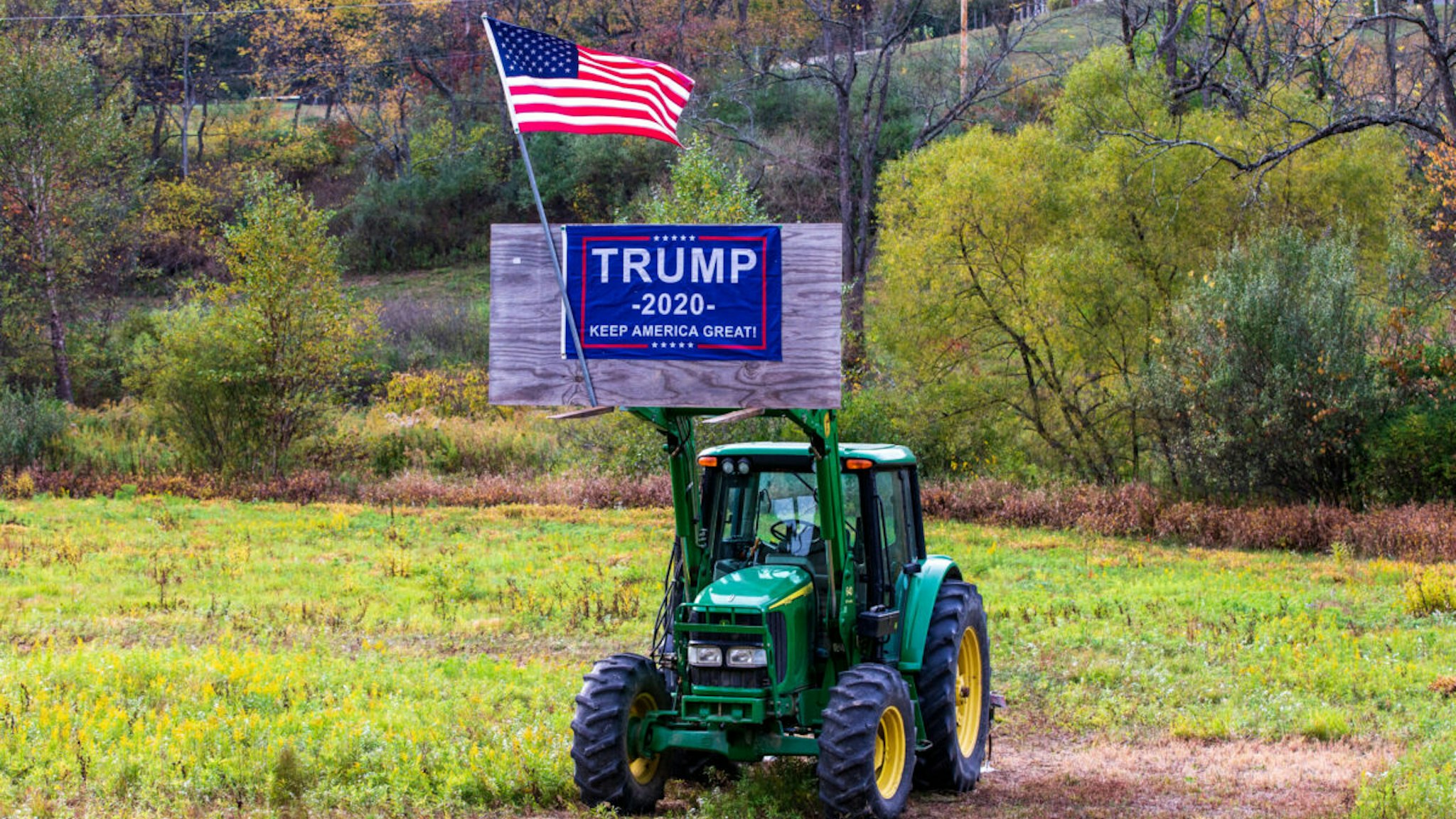 A Trump 2020 re-election sign and an American flag are displayed on a piece of farm equipment in Valley Township, Montour County, Pennsylvania.