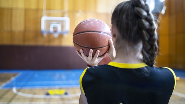 Basketball player holding a ball, photo from the back