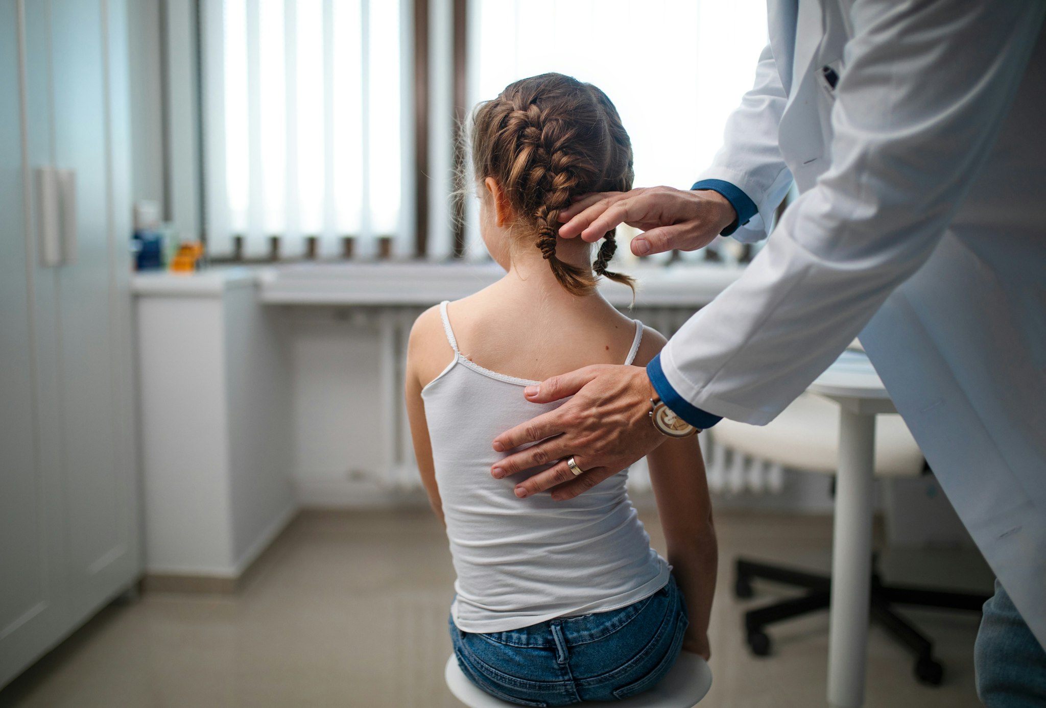 Little girl being examined by orthopedist in his office.