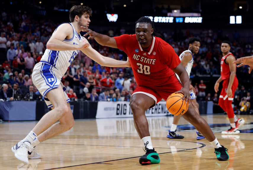 DALLAS, TEXAS - MARCH 31: DJ Burns Jr. #30 of the North Carolina State Wolfpack controls the ball as Ryan Young #15 of the Duke Blue Devils defends in the Elite 8 round of the NCAA Men's Basketball Tournament at American Airlines Center on March 31, 2024 in Dallas, Texas. (Photo by Carmen Mandato/Getty Images)