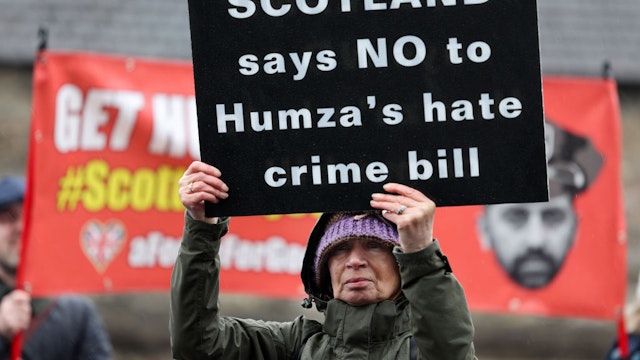 EDINBURGH, SCOTLAND - APRIL 01: Protesters demonstrate outside the Scottish Parliament as Scotland’s Hate Crime Law comes into force on April 01, 2024 in Edinburgh, Scotland. The hate crime bill, introduced today, criminalises 'threatening or abusive behaviour' intended to stir up hatred against someone's identity. It extends protection to groups including religion, age, disability, sexual orientation, and transgender identity, and applies in people's private homes and online. Despite being passed three years ago, its implementation was postponed due to concerns regarding enforcement. (Photo by Jeff J Mitchell/Getty Images)