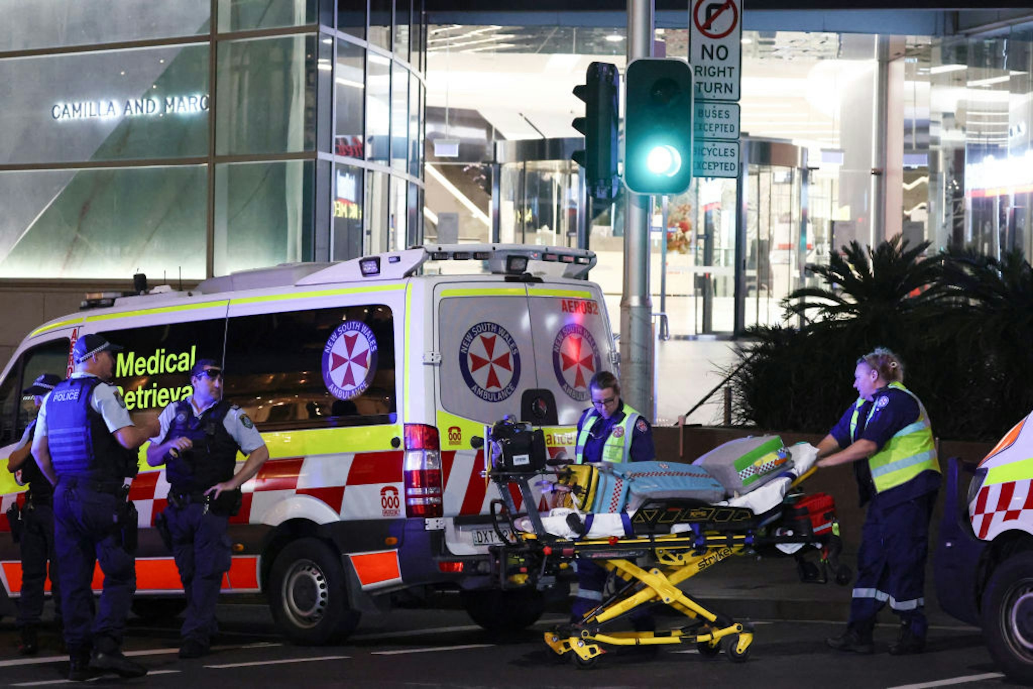 Paramedics (R) move a stretcher with medical equipment outside the Westfield Bondi Junction shopping mall after a stabbing incident in Sydney on April 13, 2024. The number of people killed by a knife-wielding assailant in a Sydney shopping centre on April 13 has climbed to six, police said. (Photo by David GRAY / AFP)