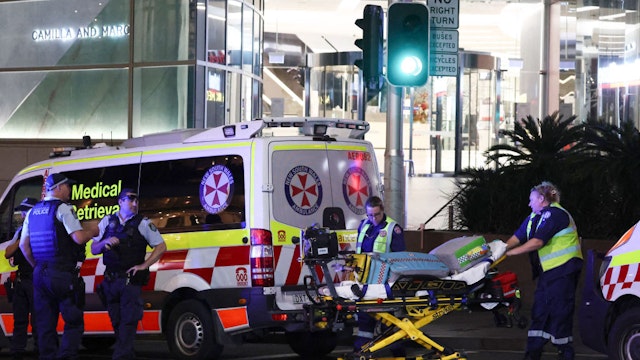 Paramedics (R) move a stretcher with medical equipment outside the Westfield Bondi Junction shopping mall after a stabbing incident in Sydney on April 13, 2024. The number of people killed by a knife-wielding assailant in a Sydney shopping centre on April 13 has climbed to six, police said. (Photo by David GRAY / AFP)