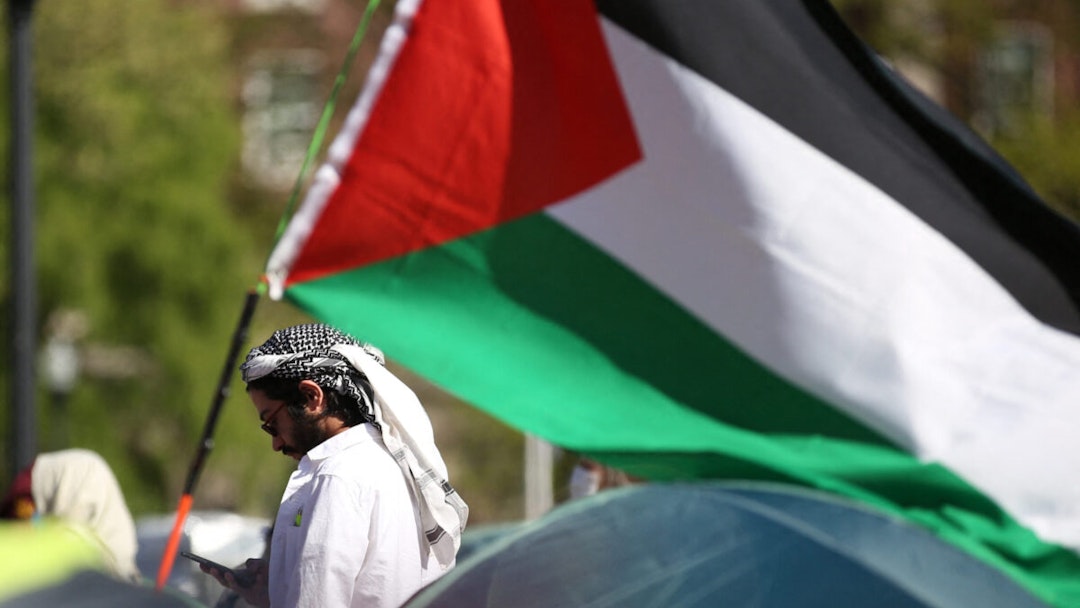 A pro-Palestinian protester stands among tents and a Palestinian flag at an encampment at Columbia University campus in New York on April 25, 2024.
