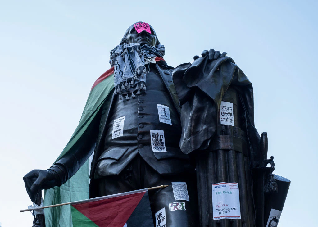 WASHINGTON, DISTRICT OF COLUMBIA, UNITED STATES - 2024/04/29: Palestinian flag and Keffiye are wrapped around the statue of George Washington at the George Washington University encampment protest . Students set up an encampment in solidarity with Palestine at George Washington University with other DC-area universities. The encampment has entered the fifth day in solidarity with college campuses across the United States. (Photo by Probal Rashid/LightRocket via Getty Images)