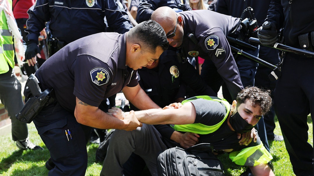 LOS ANGELES, CALIFORNIA - APRIL 24: USC public safety officers detain a pro-Palestine demonstrator during clashes after officers attempted to take down an encampment in support of Gaza at the University of Southern California on April 24, 2024 in Los Angeles, California. Pro-Palestinian encampments have sprung up at college campuses around the country recently.