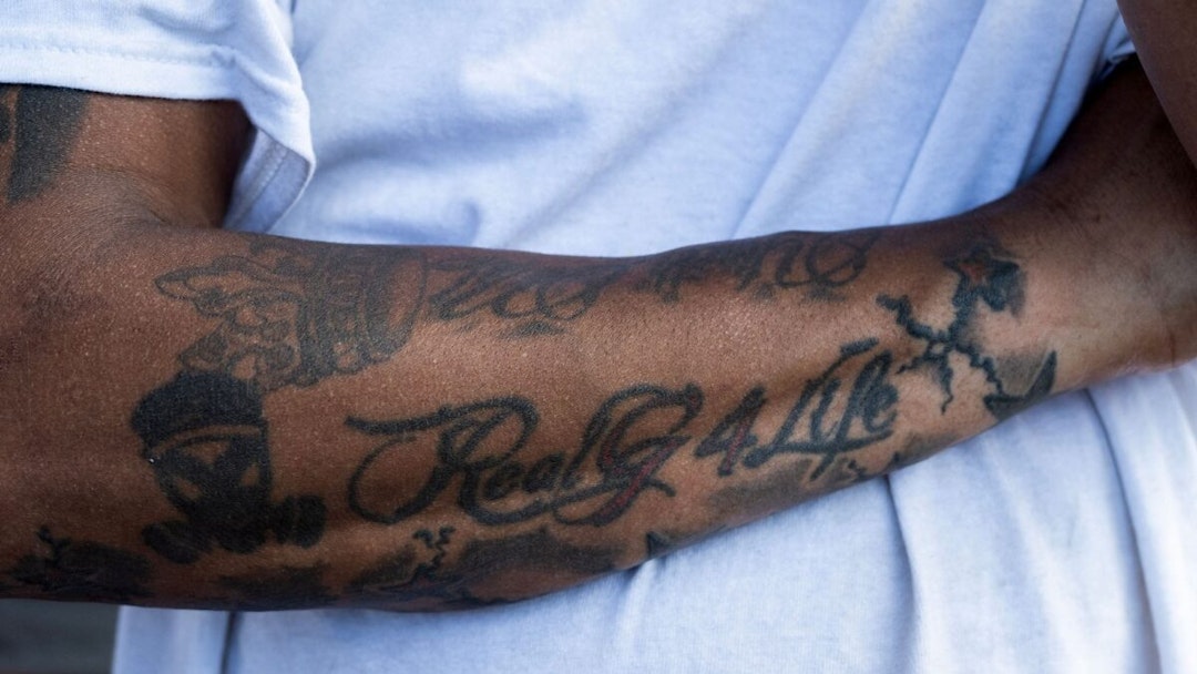 The tattoo of a migrant is seen on his arm as he waits for a bus to transport him out of Eagle Pass, Texas, on September 26, 2023 at the Mission Border Hope complex, an NGO that assists migrants after they are processed by the US Customs and Border Patrol and with transportation around the United States.
