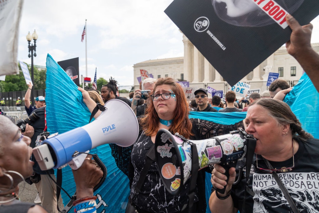 WASHINGTON, DC - JUNE 24: Lauren Handy, a member of Progressive Anti-Abortion Uprising, wears a cape as an anti-abortion demonstrator and abortion rights activist argue near the Supreme Court in Washington, D.C. on June 24, 2022. The court announced a ruling on a Mississippi abortion case overturning Roe v. Wade.