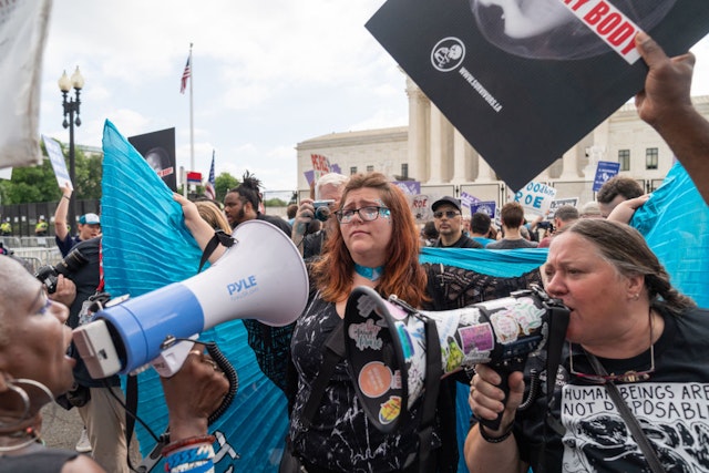 WASHINGTON, DC - JUNE 24: Lauren Handy, a member of Progressive Anti-Abortion Uprising, wears a cape as an anti-abortion demonstrator and abortion rights activist argue near the Supreme Court in Washington, D.C. on June 24, 2022. The court announced a ruling on a Mississippi abortion case overturning Roe v. Wade.