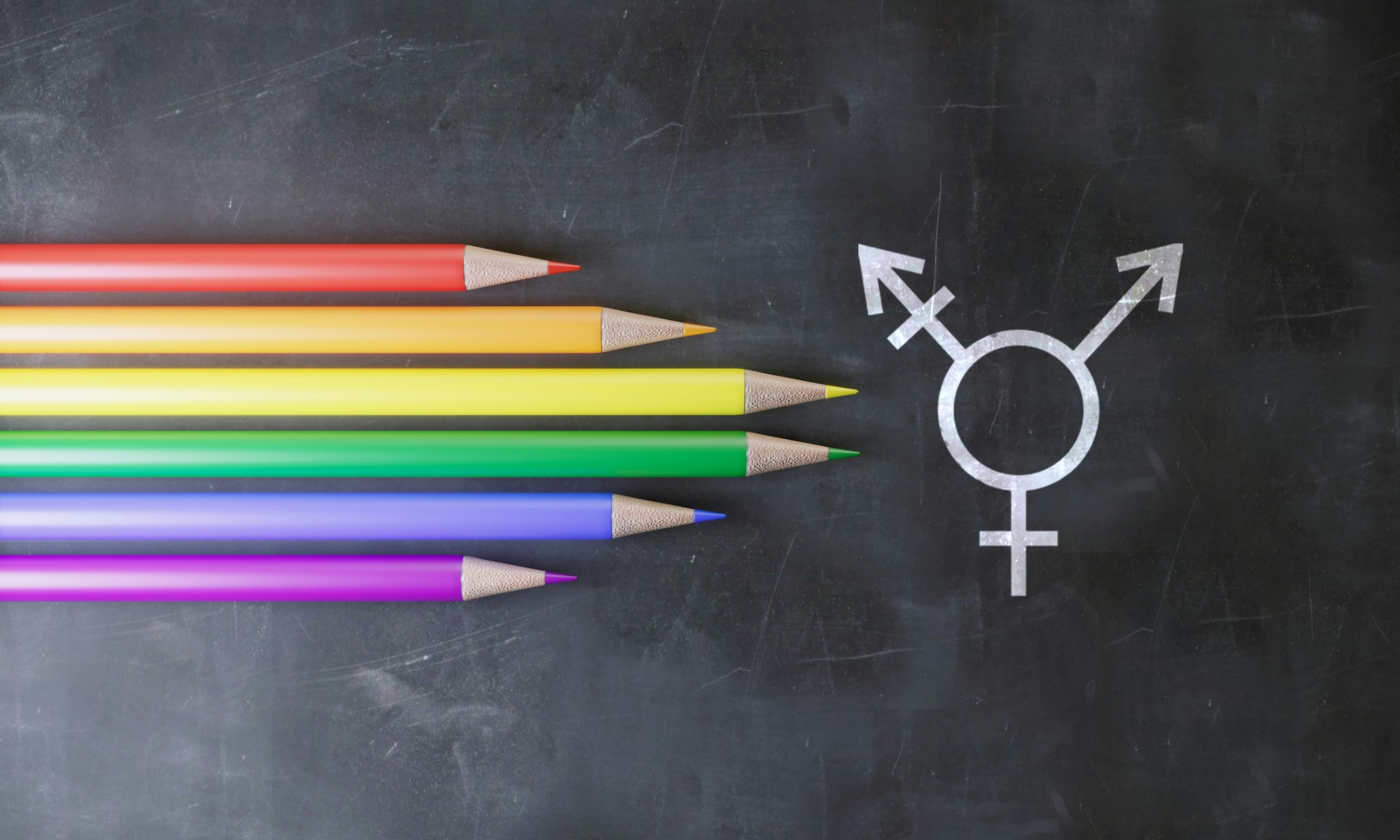 Transgender symbol and pencils with the color of Lgbt flag on the blackboard.