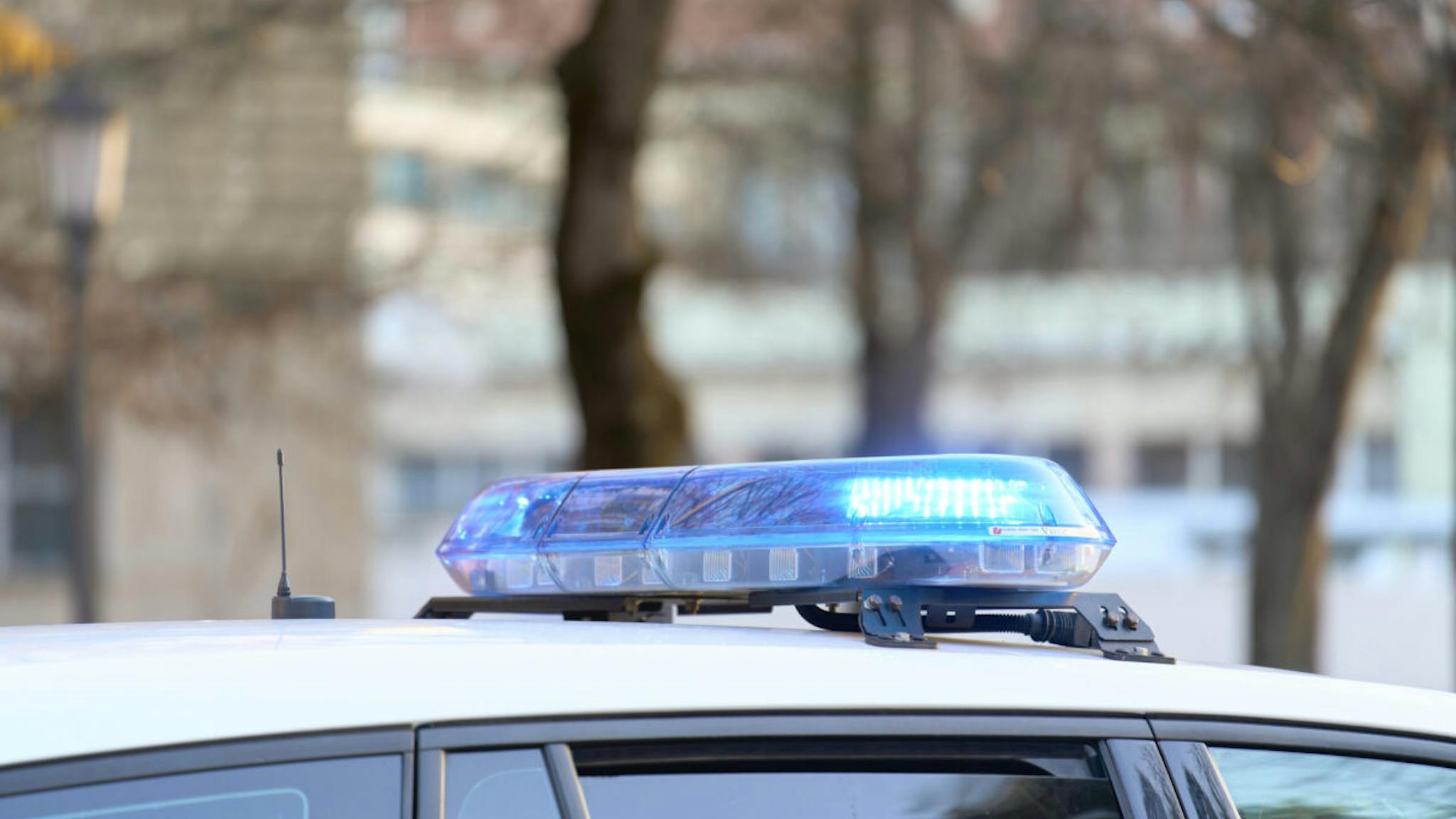 Police a close-up view of a police vehicle with blue lights patrolling near a public park with the windows and doors closed