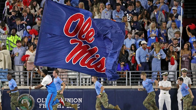 OXFORD, MISSISSIPPI - OCTOBER 07: Mississippi Rebels cheerleader runs with a flag during the game against the Arkansas Razorbacks at Vaught-Hemingway Stadium on October 07, 2023 in Oxford, Mississippi. (Photo by Justin Ford/Getty Images)