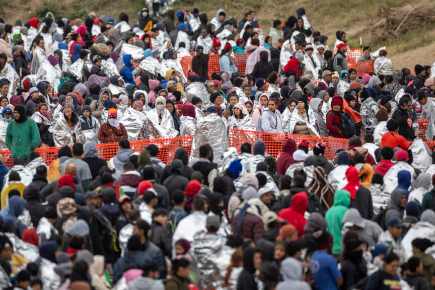 EAGLE PASS, TEXAS - DECEMBER 20: Immigrants wait to be processed at a U.S. Border Patrol transit center after they crossed the border from Mexico on December 20, 2023 in Eagle Pass, Texas. A late-year surge of migrants crossing the U.S.southern border has overwhelmed U.S. immigration officials.