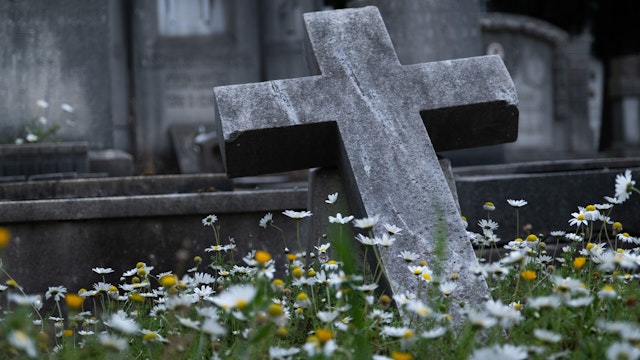 The city cemetery with old unkempt graves. Stone tombstones, metal crosses. City cemetery. Gravestones and stone crosses, abandoned and overgrown with grass graves of unknown people. The concept of death, the end of life, sadness, sorrow and loneliness. - stock photo