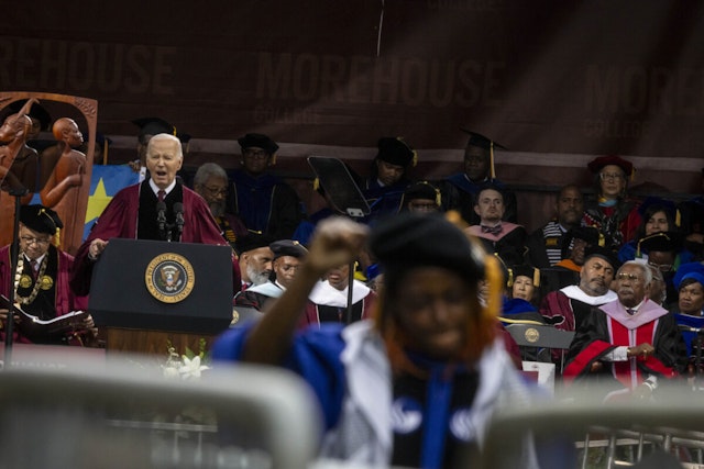 A faculty member raises a fist as US President Joe Biden speaks during a graduation ceremony at Morehouse College in Atlanta, Georgia, US, on Sunday, May 19, 2024.